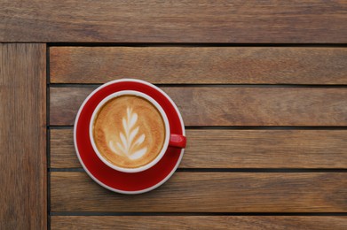 Cup of aromatic coffee on wooden table, top view. Space for text