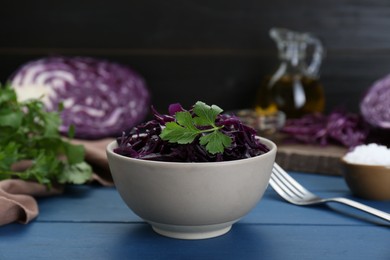 Photo of Tasty red cabbage sauerkraut with parsley on light blue wooden table