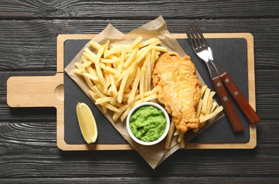 Photo of British Traditional Fish and potato chips on wooden background, top view