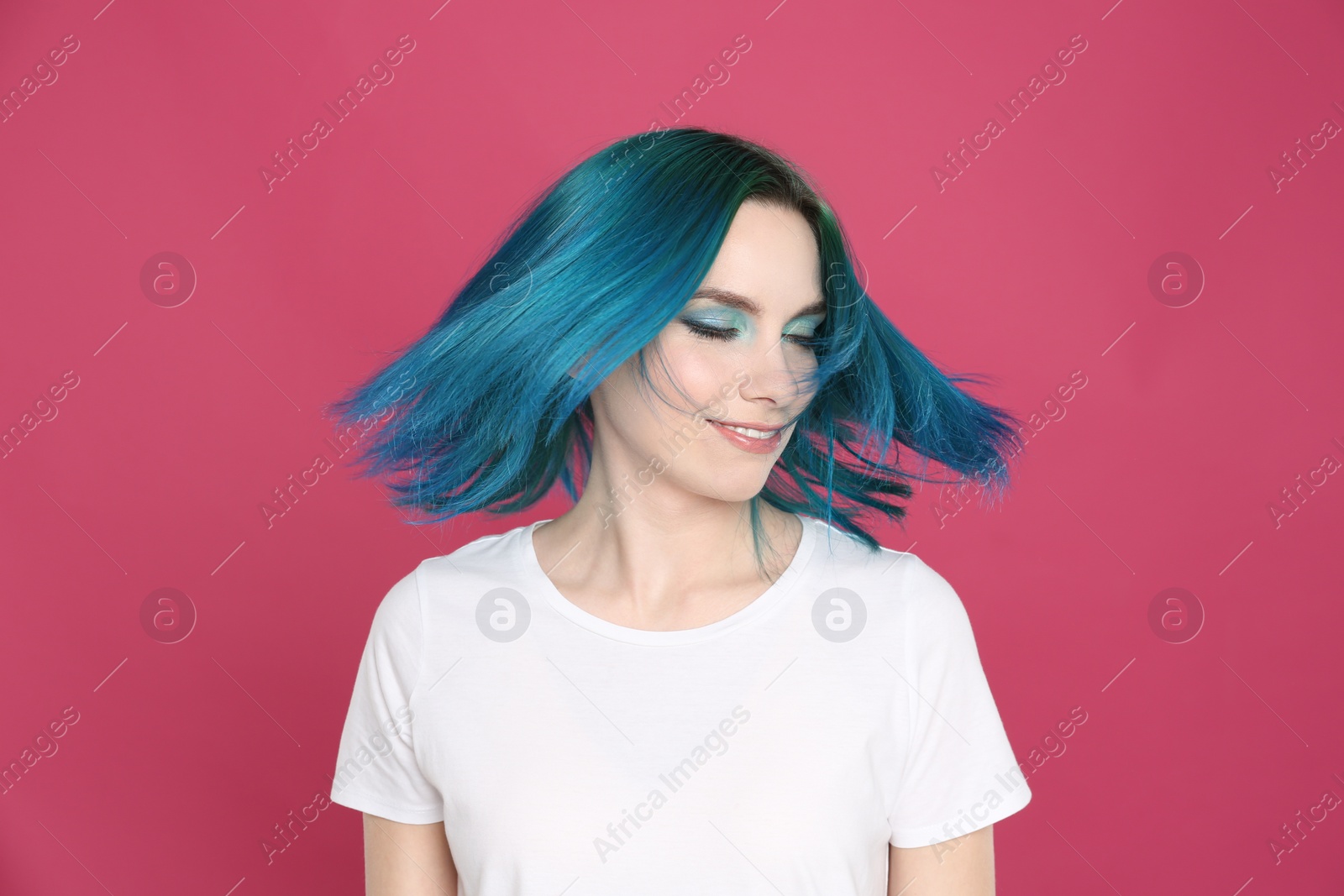 Photo of Young woman with bright dyed hair on pink background