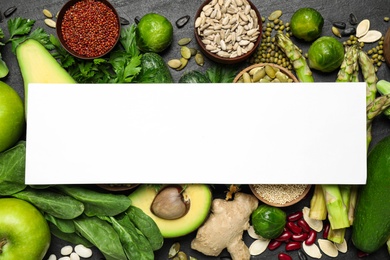 Flat lay composition with different vegetables, seeds and fruits on black table, space for text. Healthy diet