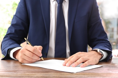 Photo of Lawyer working with documents at table, focus on hands