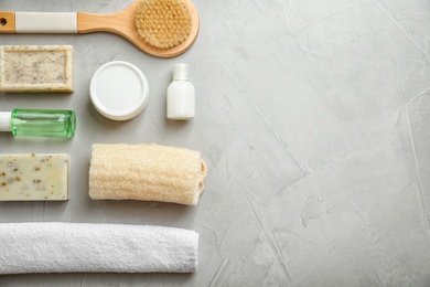 Photo of Flat lay composition with spa cosmetics and towel on grey background