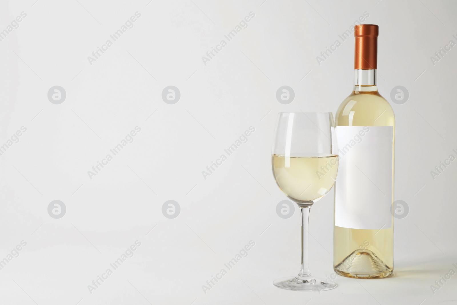 Photo of Bottle and glass with delicious wine on white background
