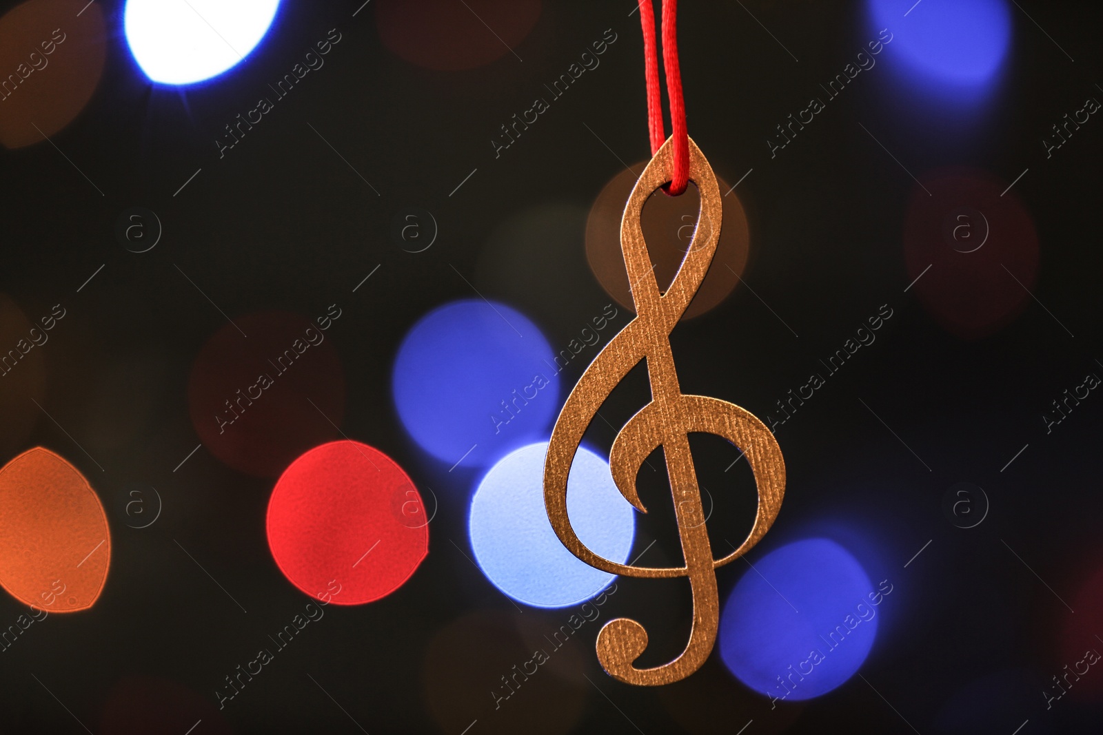 Photo of Wooden treble clef against blurred lights. Christmas music