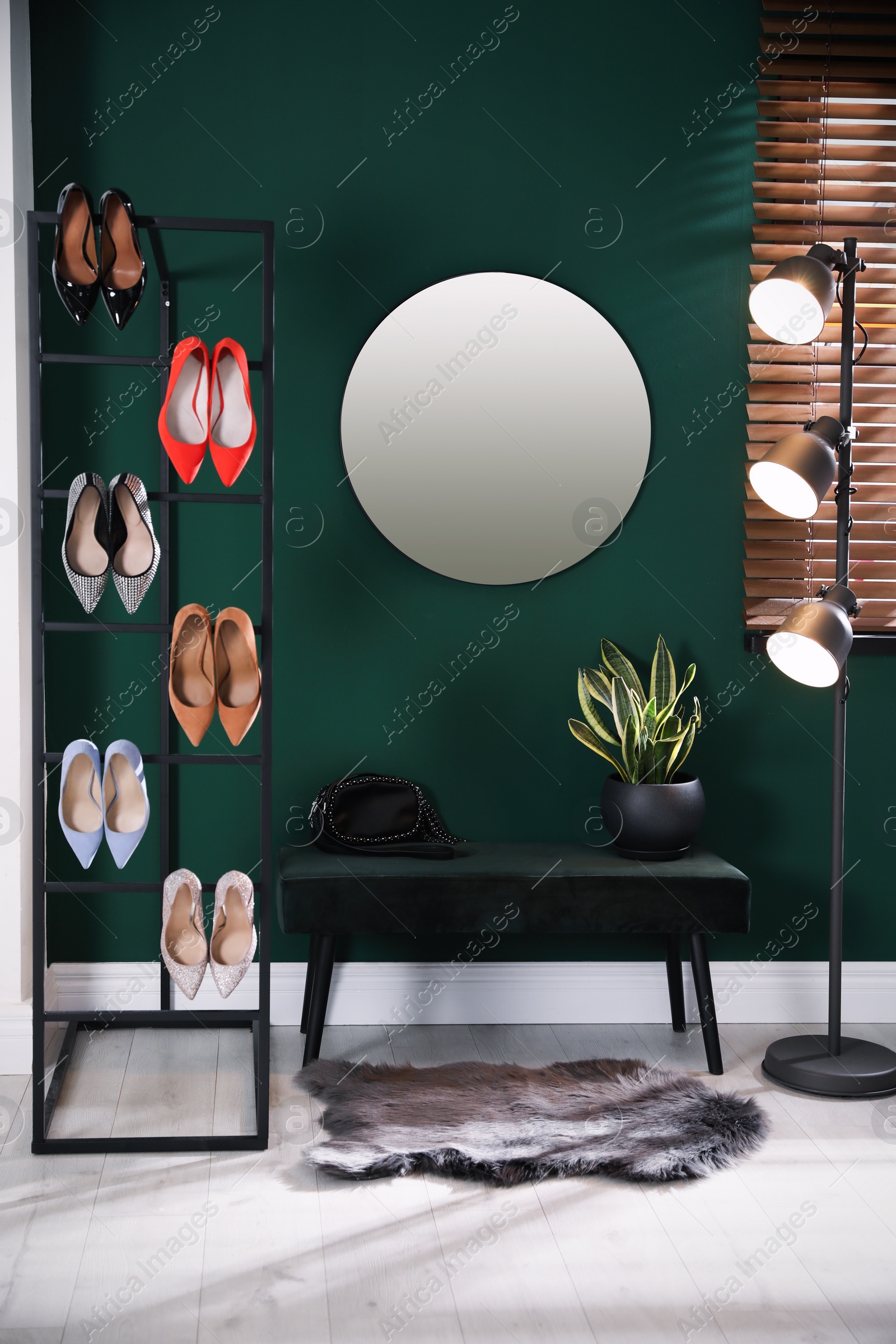 Photo of Hallway interior with storage rack, stylish women's shoes and bench