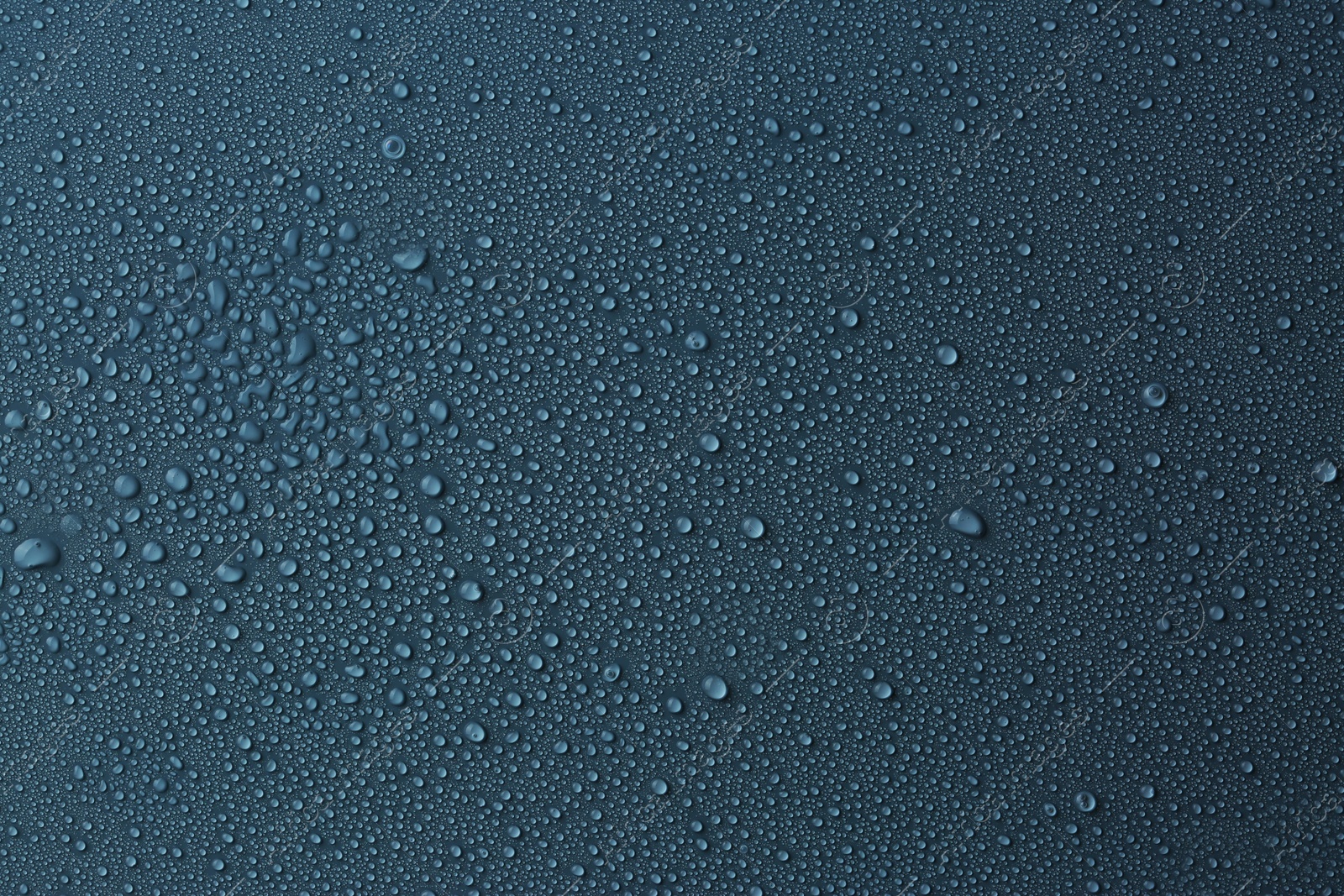 Photo of Many water drops on dark dusty blue background