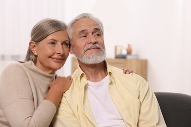 Portrait of affectionate senior couple at home, space for text