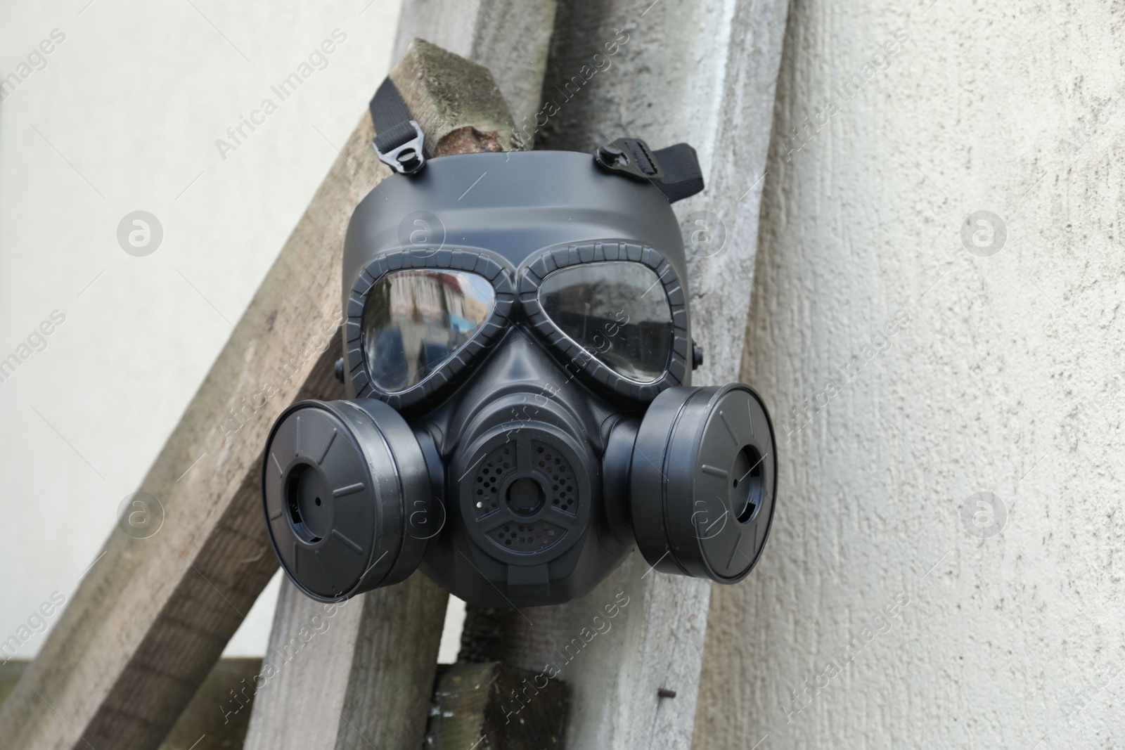 Photo of One gas mask hanging on building outdoors. Safety equipment