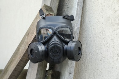 One gas mask hanging on building outdoors. Safety equipment