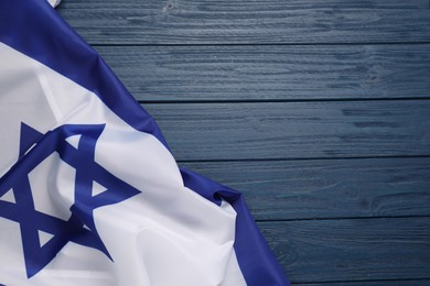 Photo of Flag of Israel on blue wooden background, top view and space for text. National symbol