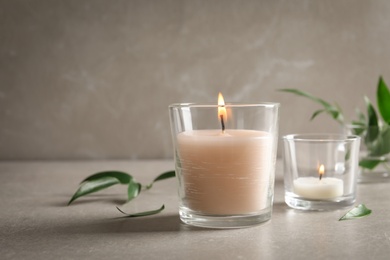 Photo of Burning wax candles in glasses on table