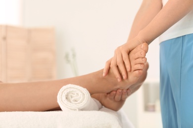 Photo of Woman receiving foot massage in wellness center, closeup