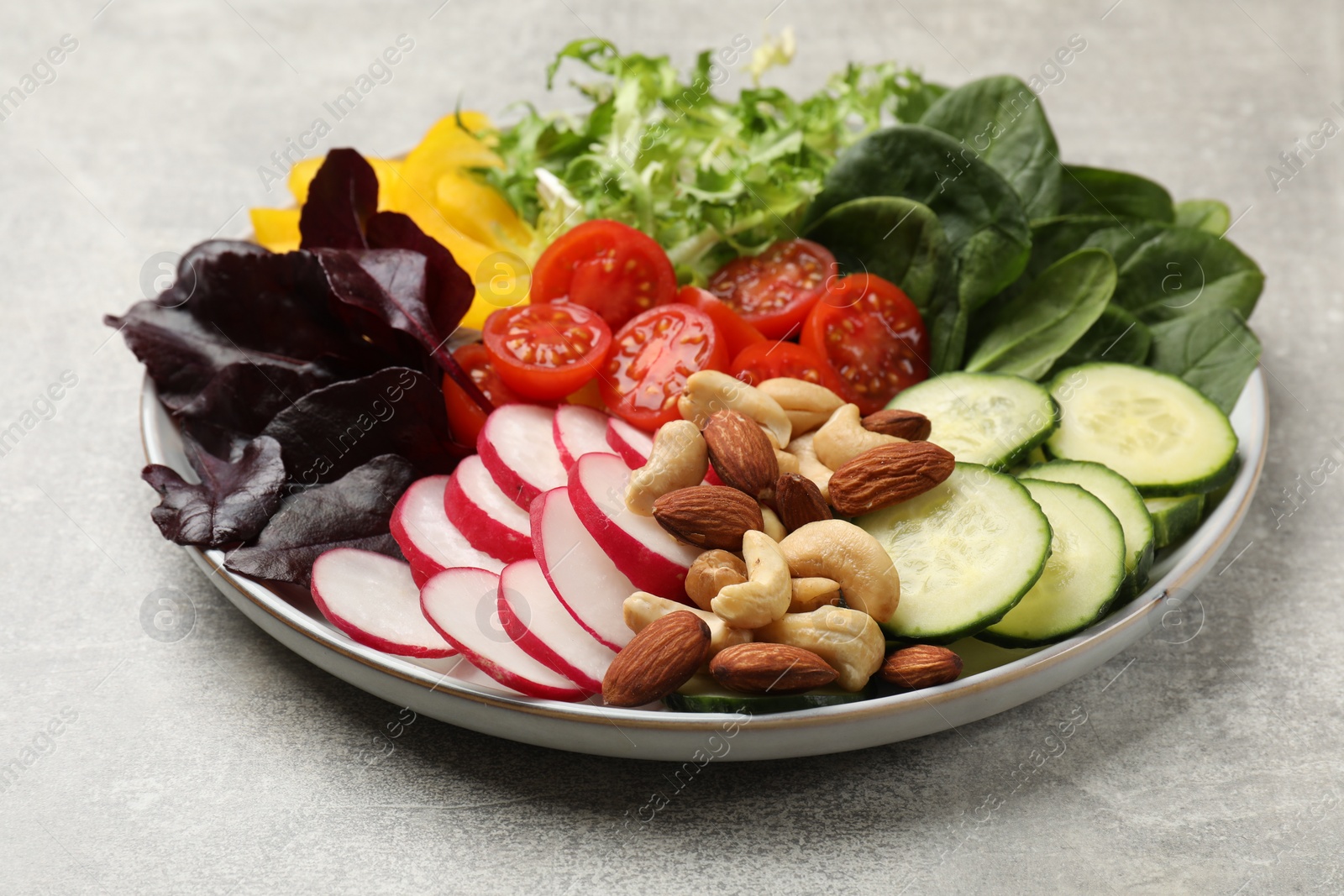 Photo of Balanced diet and vegetarian foods. Plate with different delicious products on grey table, closeup