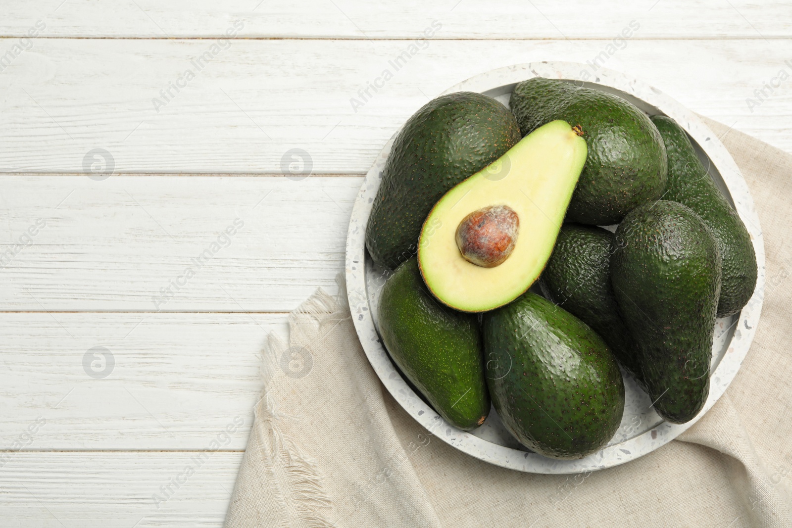 Photo of Delicious ripe avocados om white wooden table, top view. Space for text