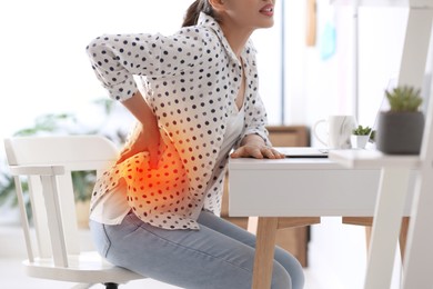 Image of Woman suffering from back pain in office. Bad posture problem