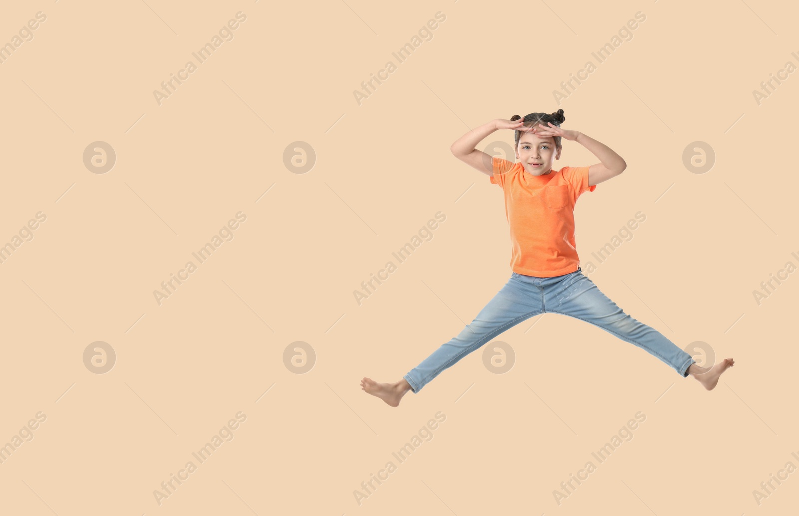 Image of Cute girl jumping on beige background, space for text