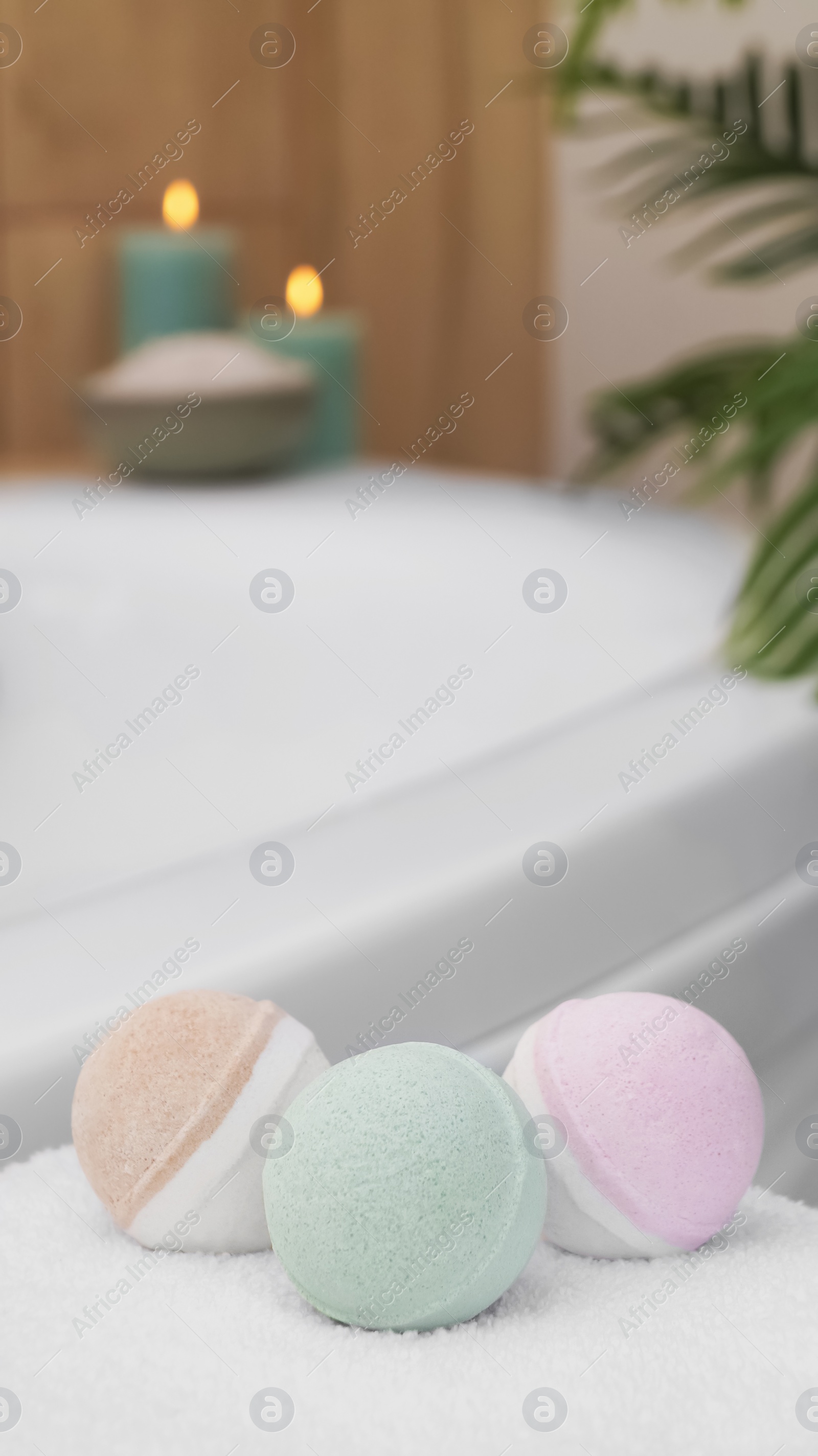 Photo of Colorful bath bombs on white towel in bathroom