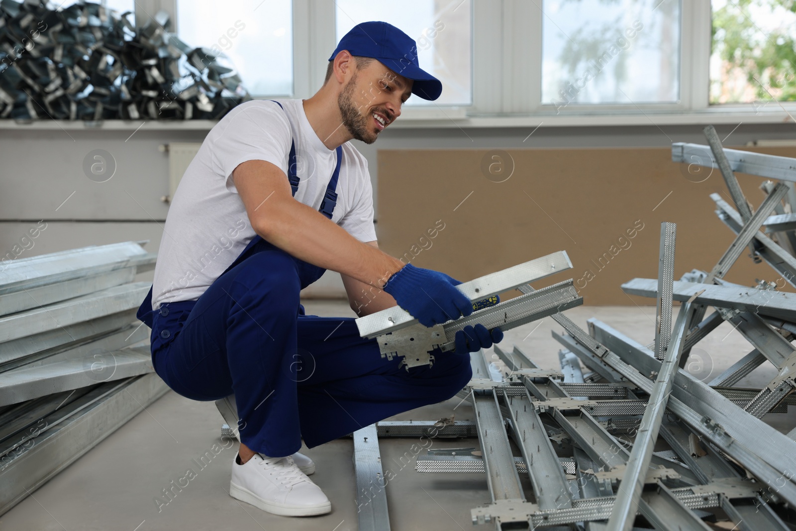 Photo of Construction worker with used building materials in room prepared for renovation