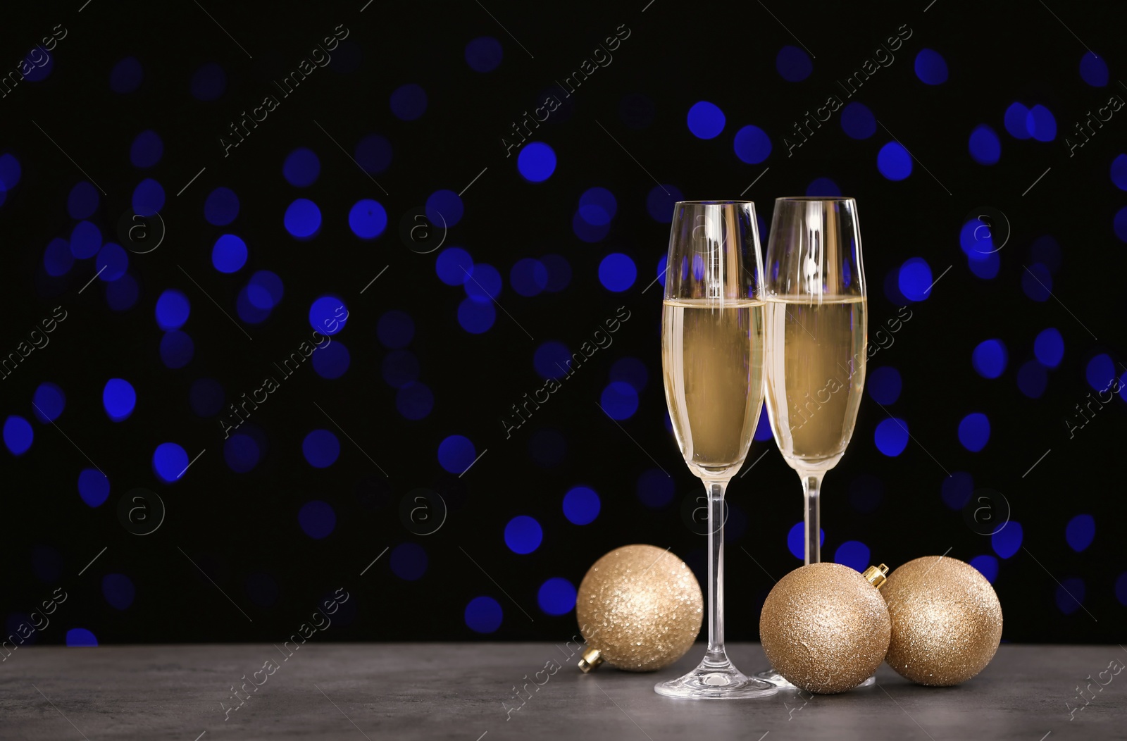 Photo of New year composition with champagne and space for text against blurred Christmas lights