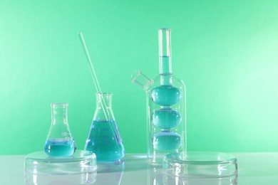 Photo of Laboratory analysis. Different glassware on table against green background