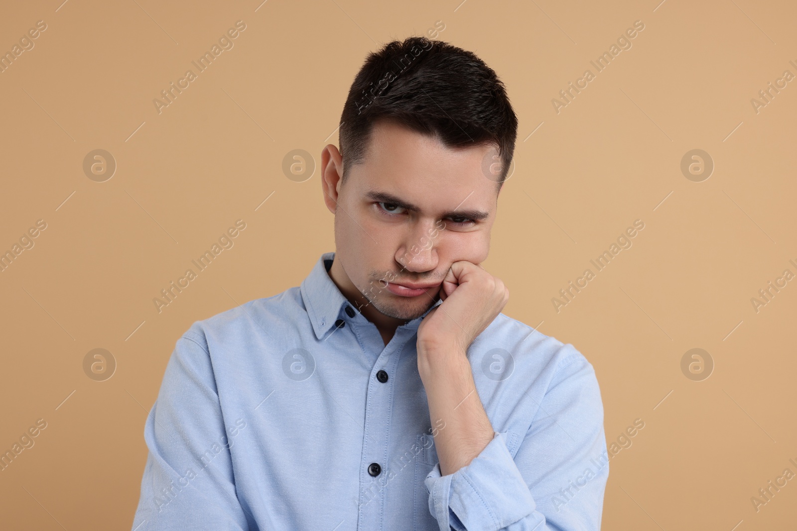 Photo of Portrait of resentful man on beige background