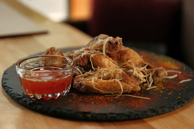Photo of Tasty BBQ wings served on table in cafe