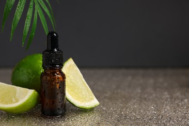 Bottle of organic cosmetic product and sliced lime on wet surface, space for text