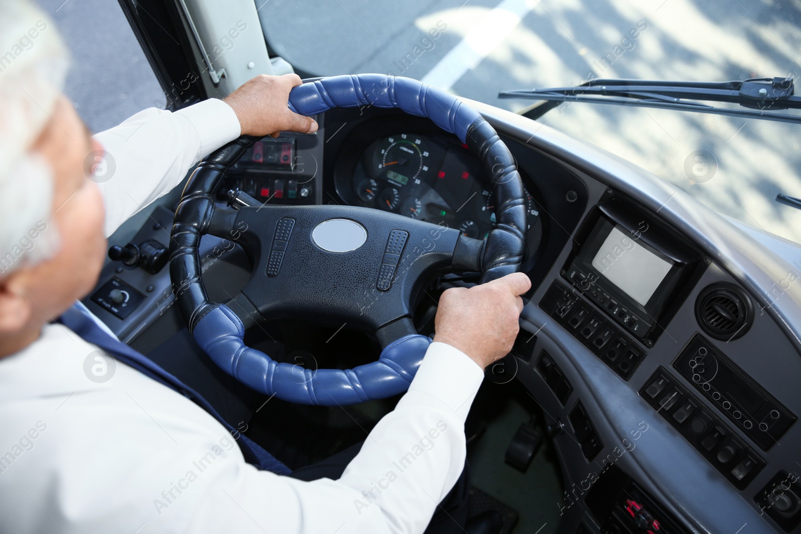 Photo of Professional bus driver at steering wheel. Passenger transportation