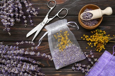 Scented sachet with mixed dried flowers and scissors on wooden table, flat lay