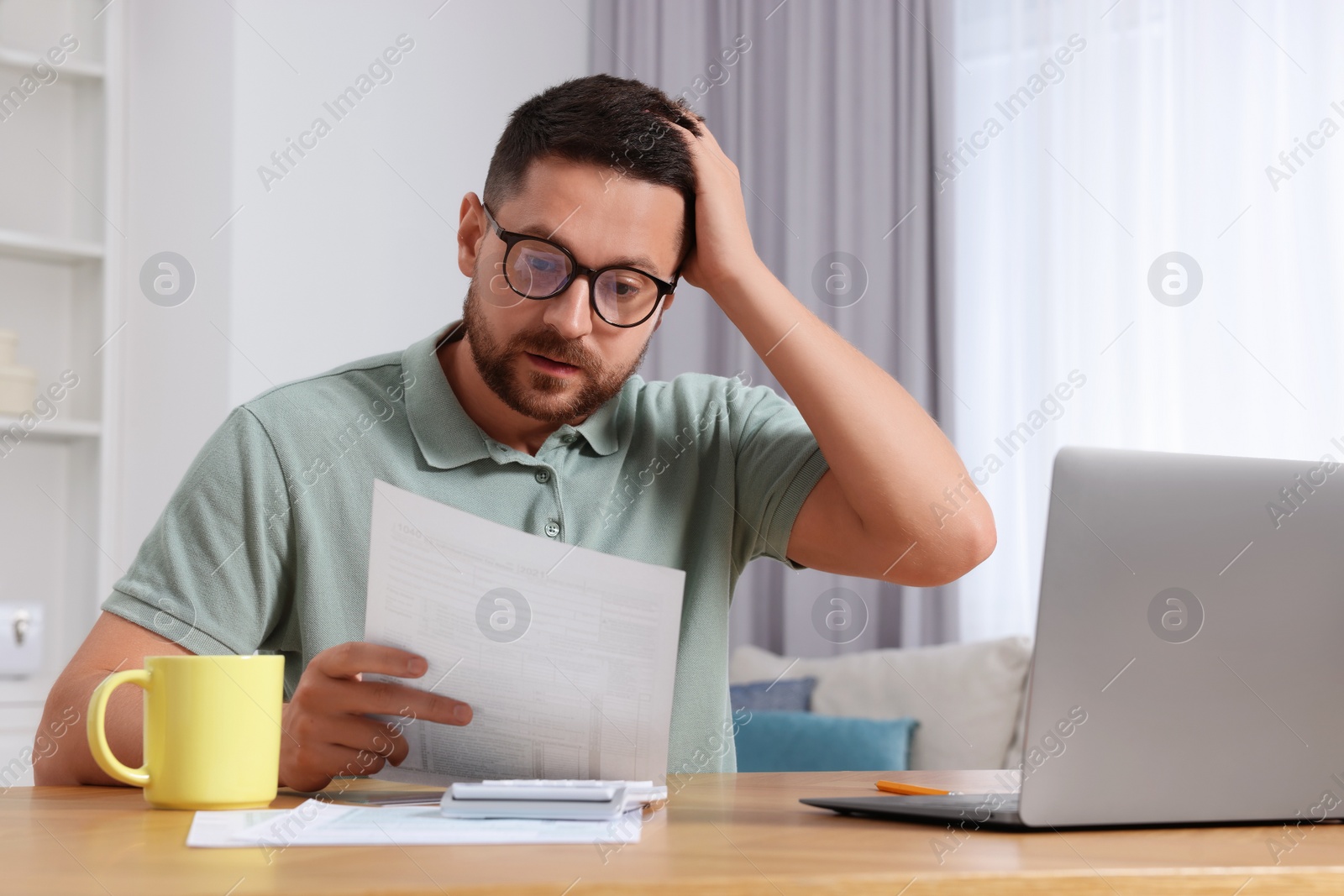 Photo of Man doing taxes at table in room