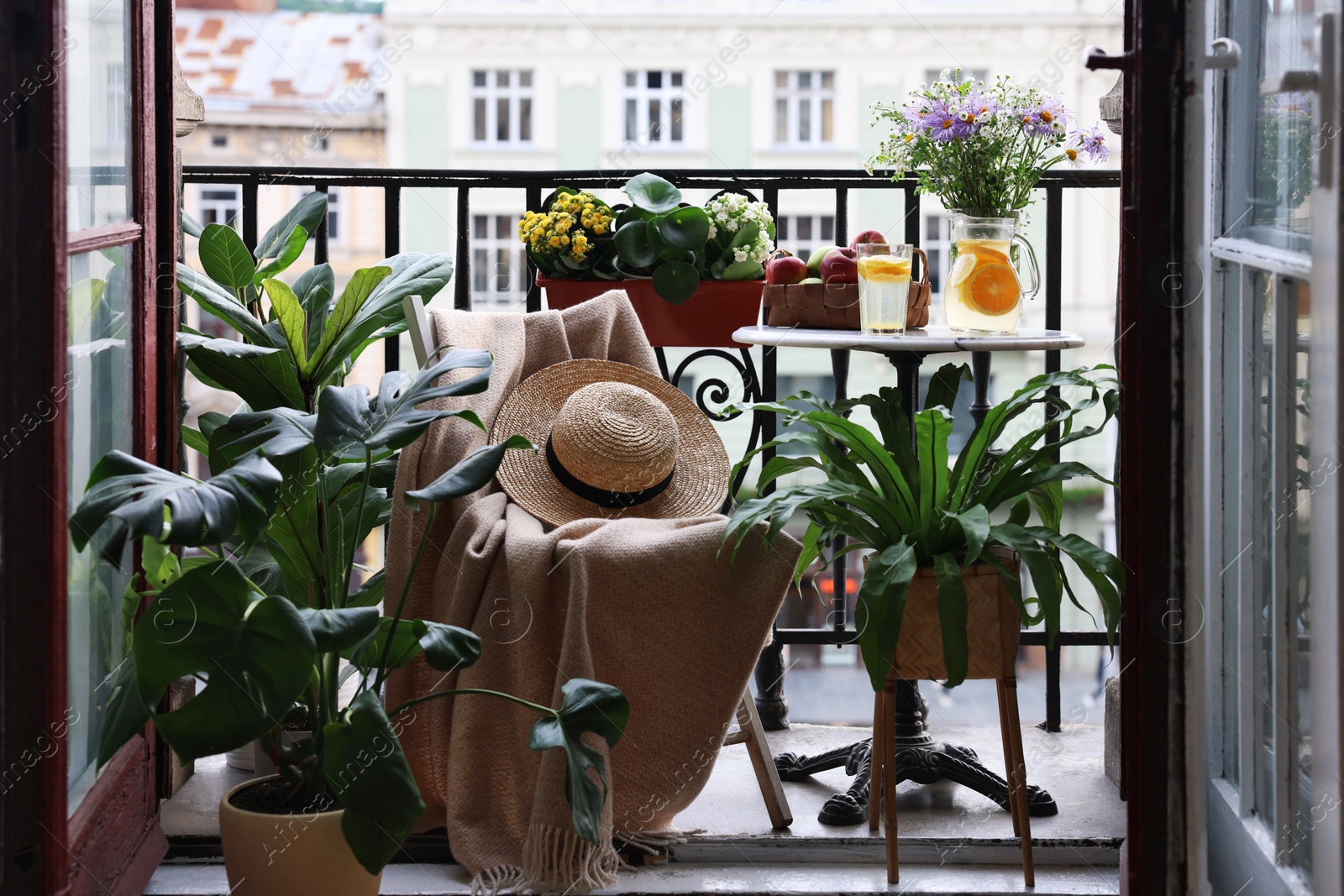 Photo of Relaxing atmosphere. Stylish furniture surrounded by beautiful houseplants on balcony