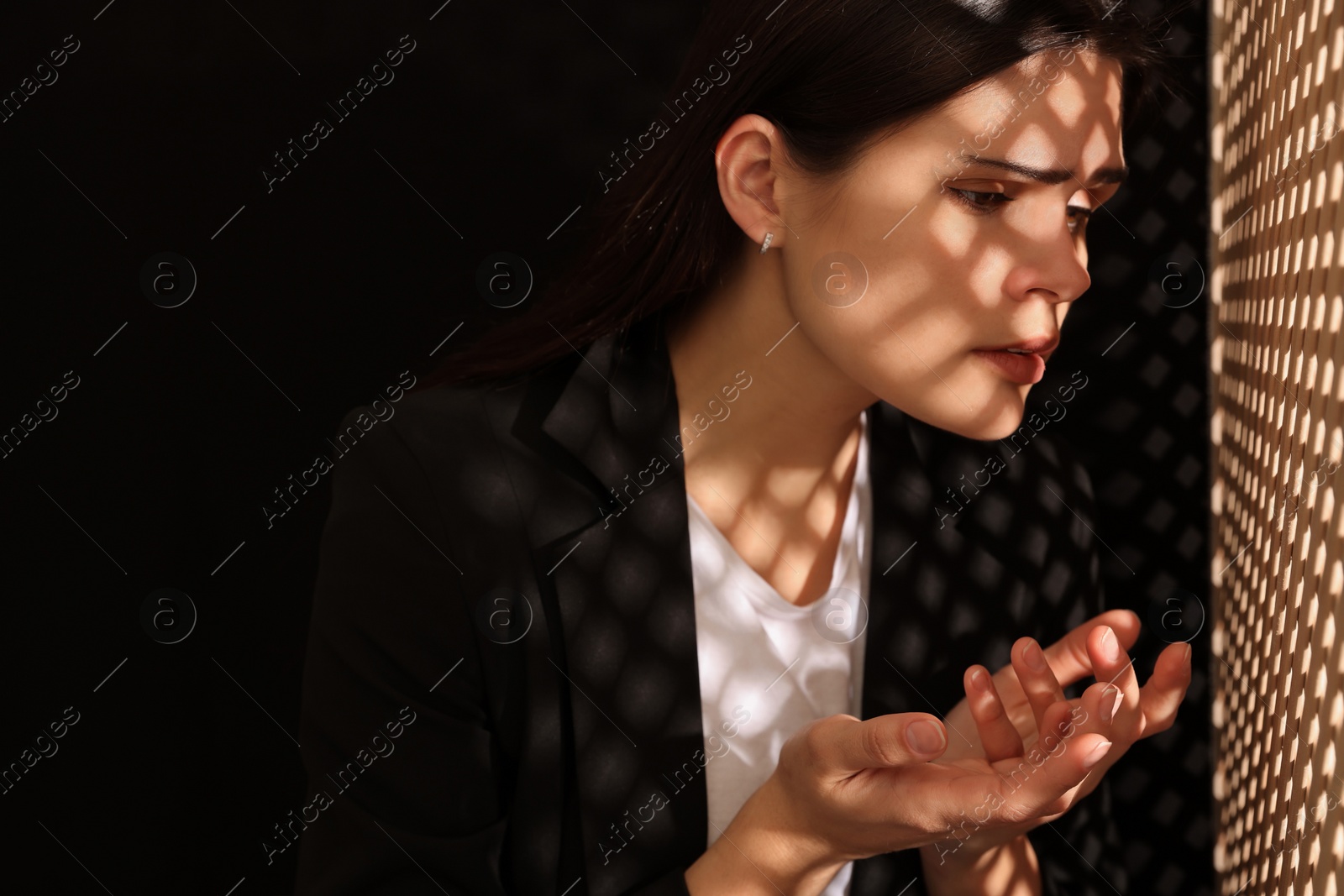 Photo of Woman talking to priest during confession near wooden partition in booth, space for text