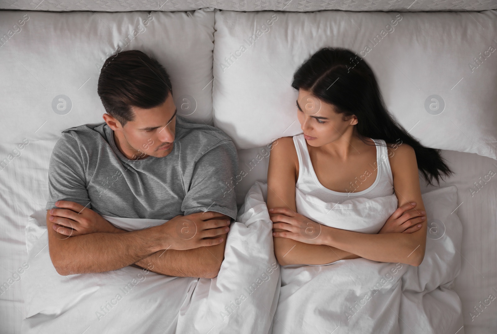 Photo of Couple with relationship problems in bed at home, top view