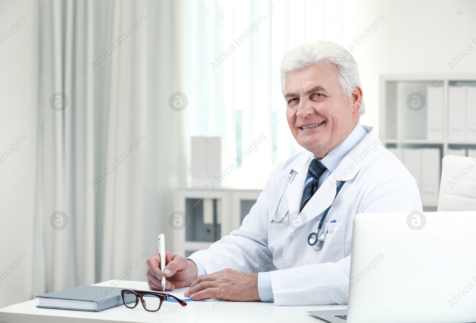 Photo of Portrait of senior doctor in white coat at workplace