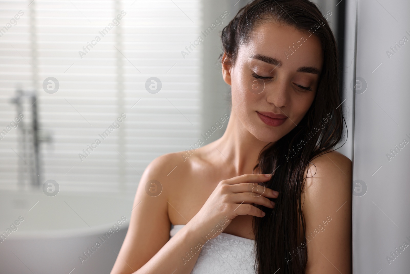 Photo of Beautiful young woman after shower in bathroom. Space for text