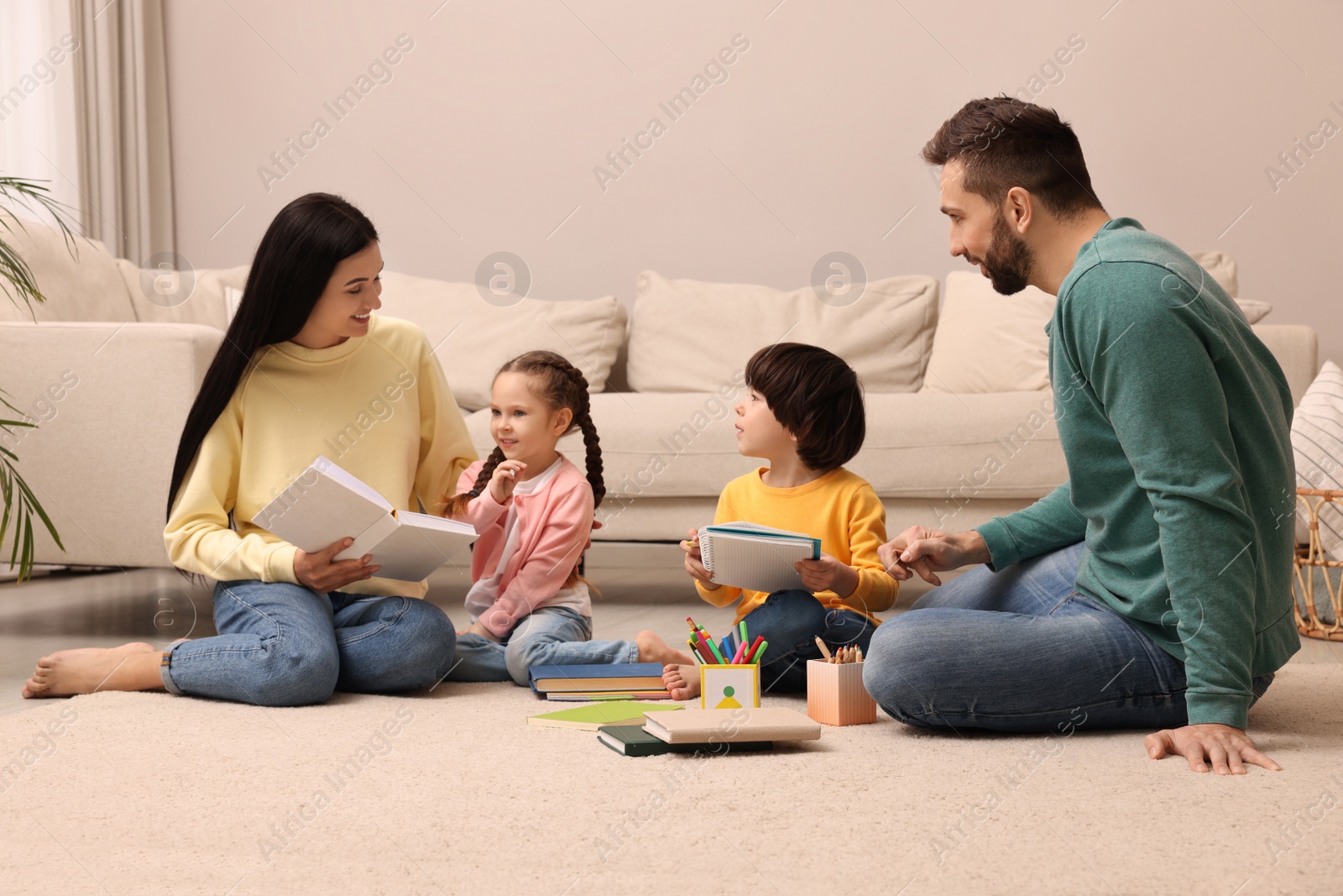 Photo of Happy family spending time together on floor in living room