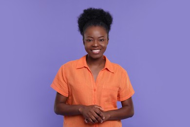 Portrait of happy young woman on purple background