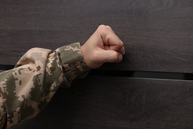 Photo of Military commissariat representative knocking on wooden door, closeup