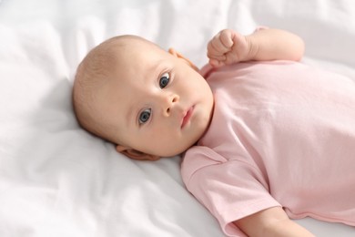 Cute little baby lying on white sheets