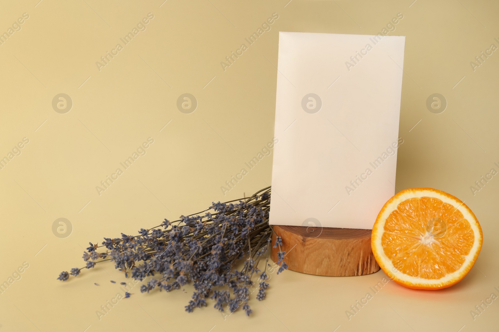 Photo of Scented sachet, dried lavender and half of orange on beige background