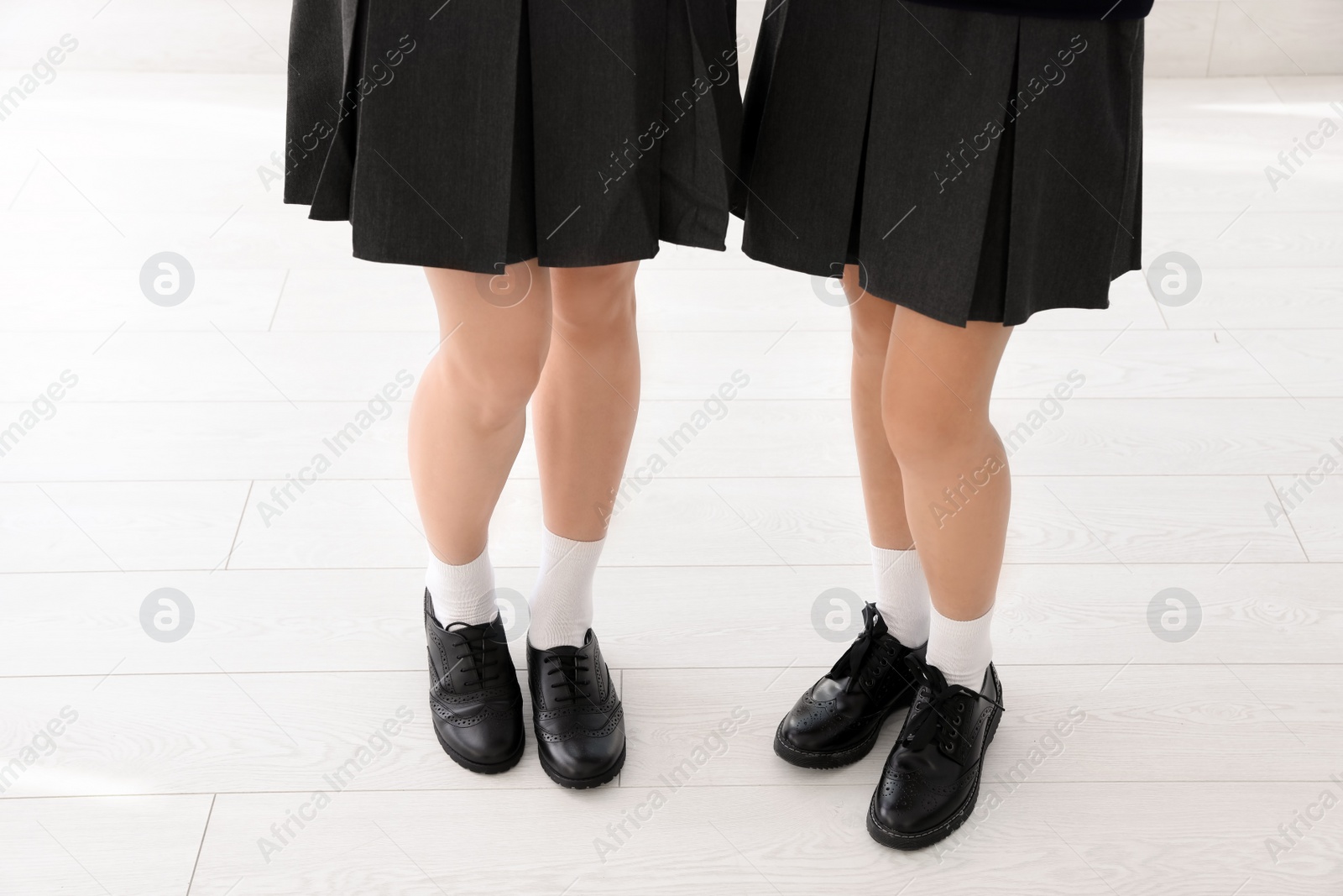 Photo of Girls in stylish school uniform indoors, focus on legs