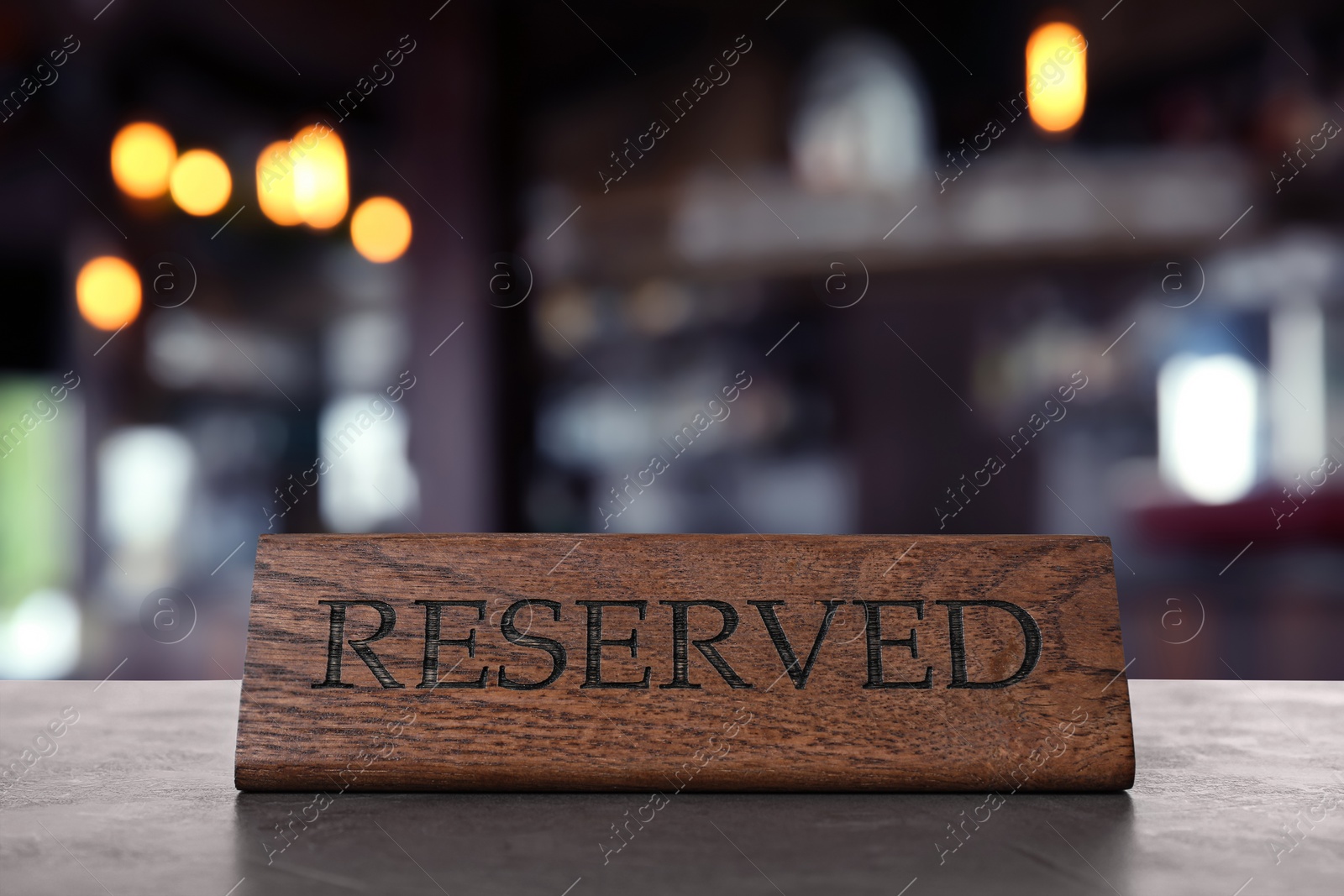 Image of Wooden sign Reserved on grey table in restaurant