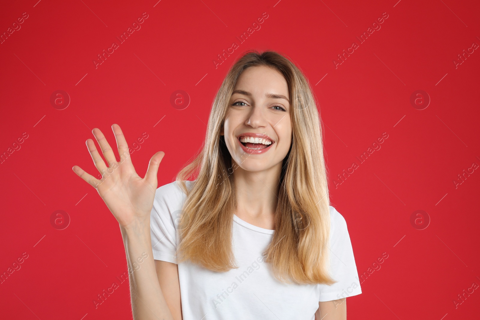 Photo of Woman showing number five with her hand on red background