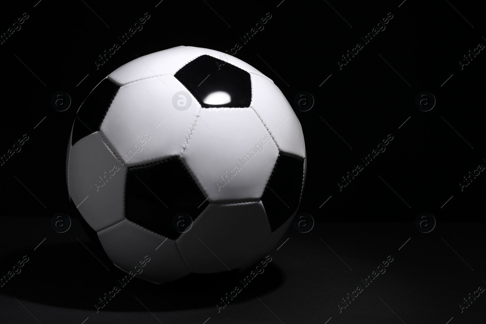 Photo of One soccer ball on black background, space for text. Sports equipment
