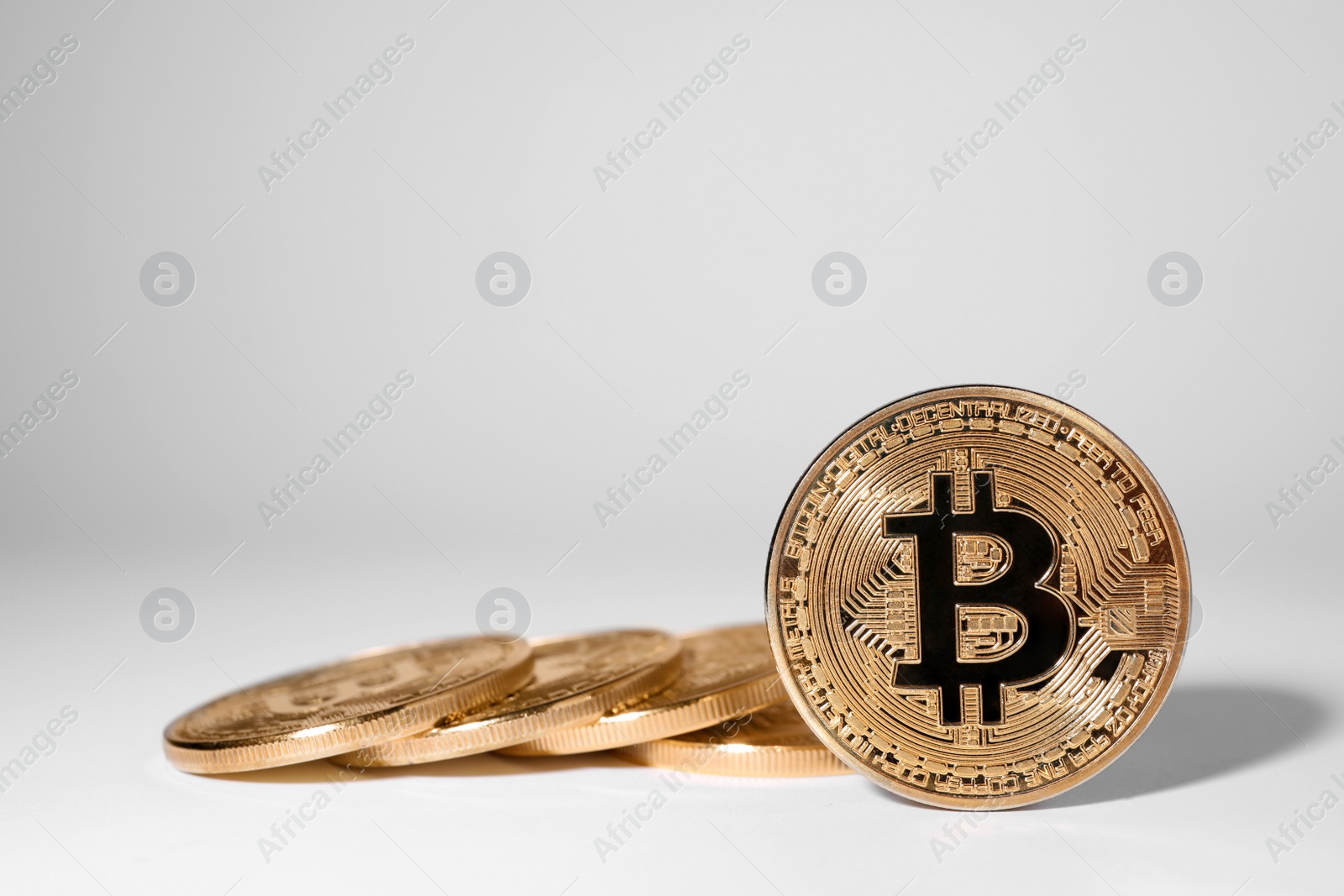 Photo of Shiny gold bitcoins on light background, space for text. Digital currency