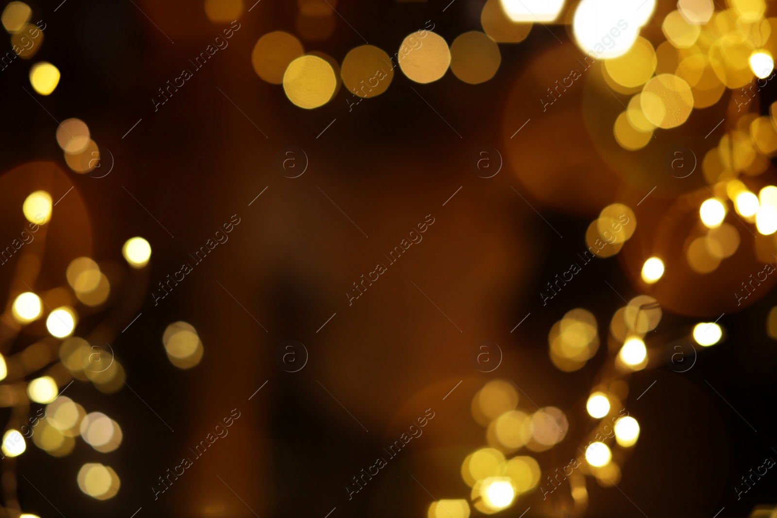 Photo of Blurred view of glowing lights on color background. Winter holiday