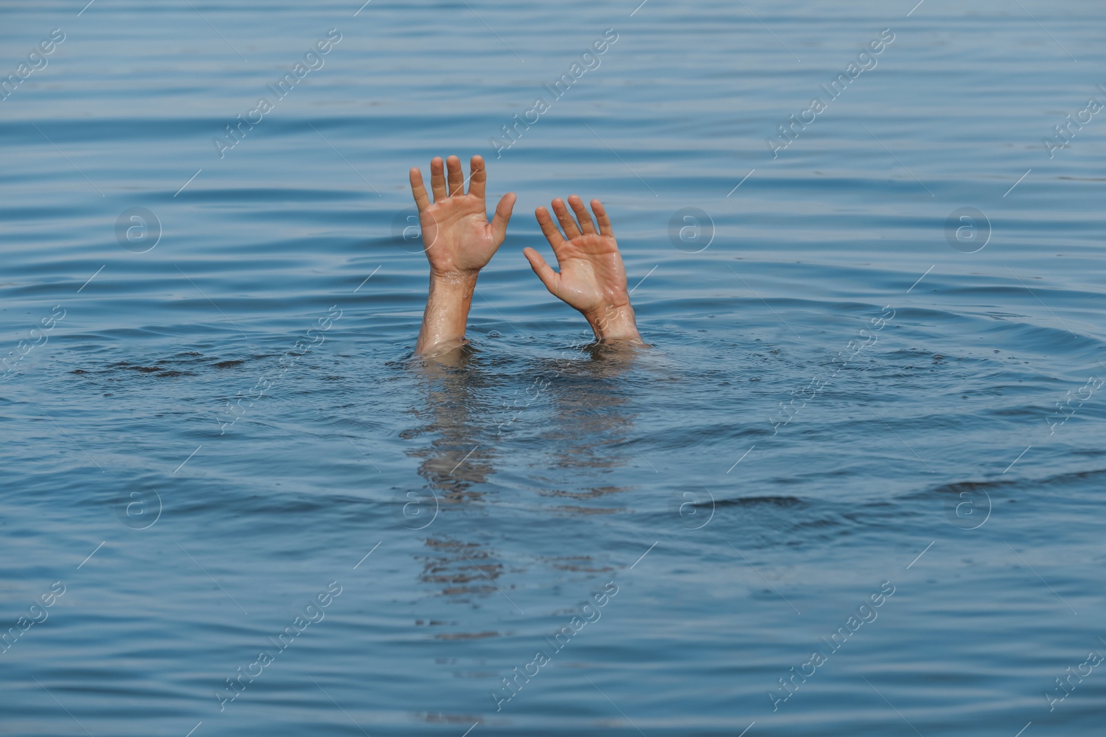 Photo of Drowning man reaching for help in sea, closeup