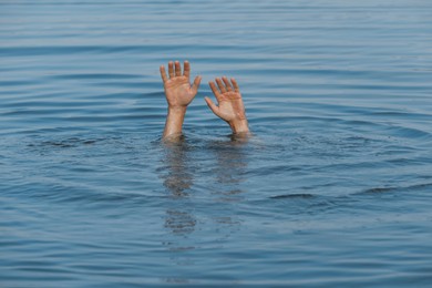 Drowning man reaching for help in sea, closeup