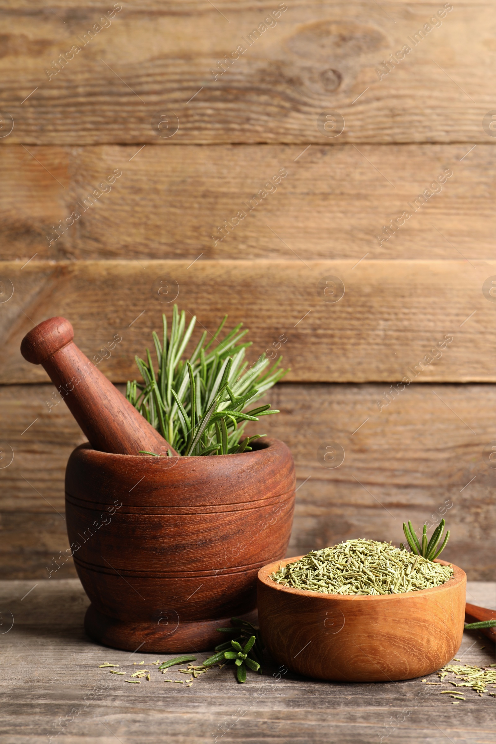 Photo of Fresh and dry rosemary on wooden table